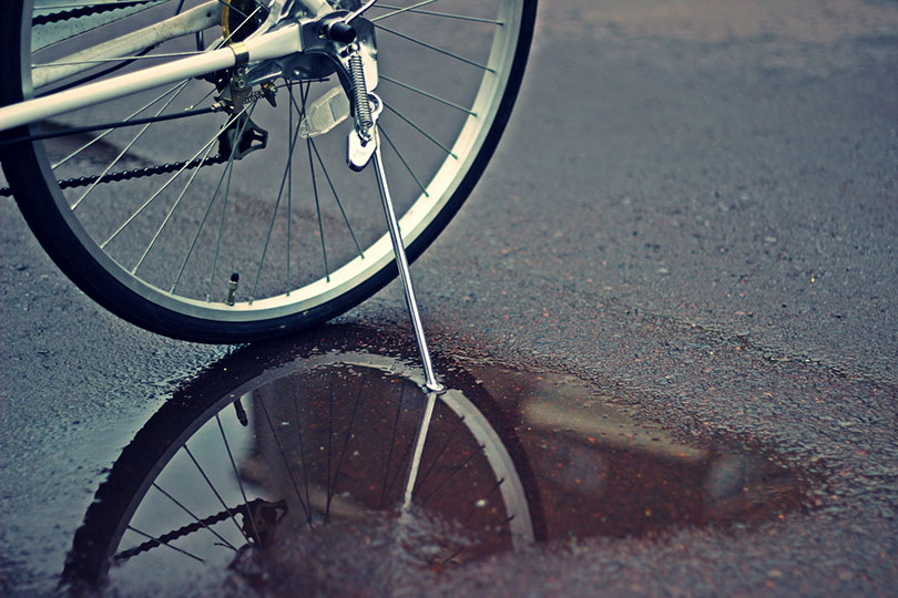 水たまりに反射する自転車のタイヤ