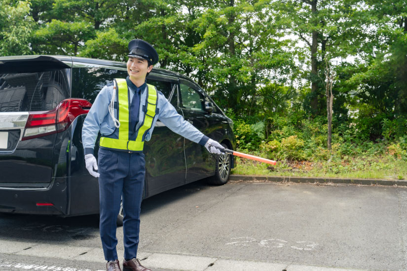 スーパーの駐車場警備をする警備員