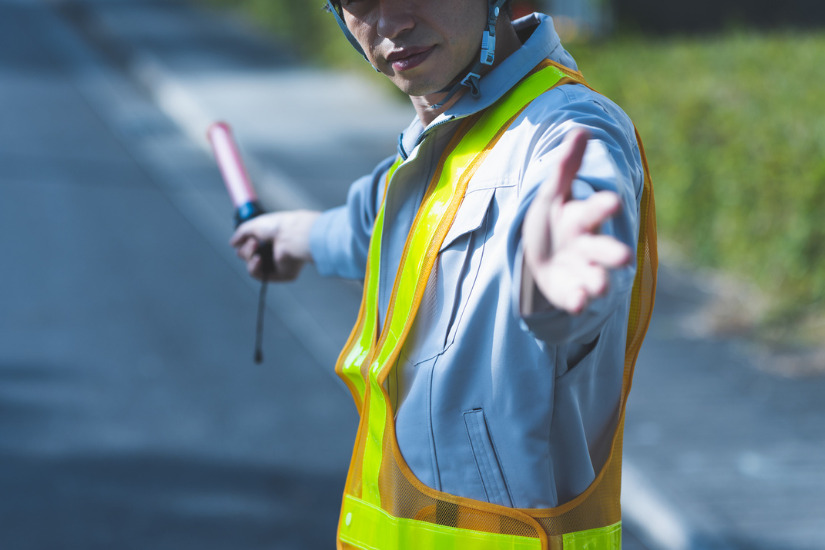 道路で交通整備をする警備員