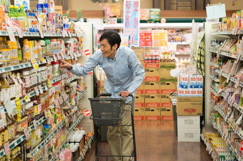 スーパーで商品を選ぶ男性